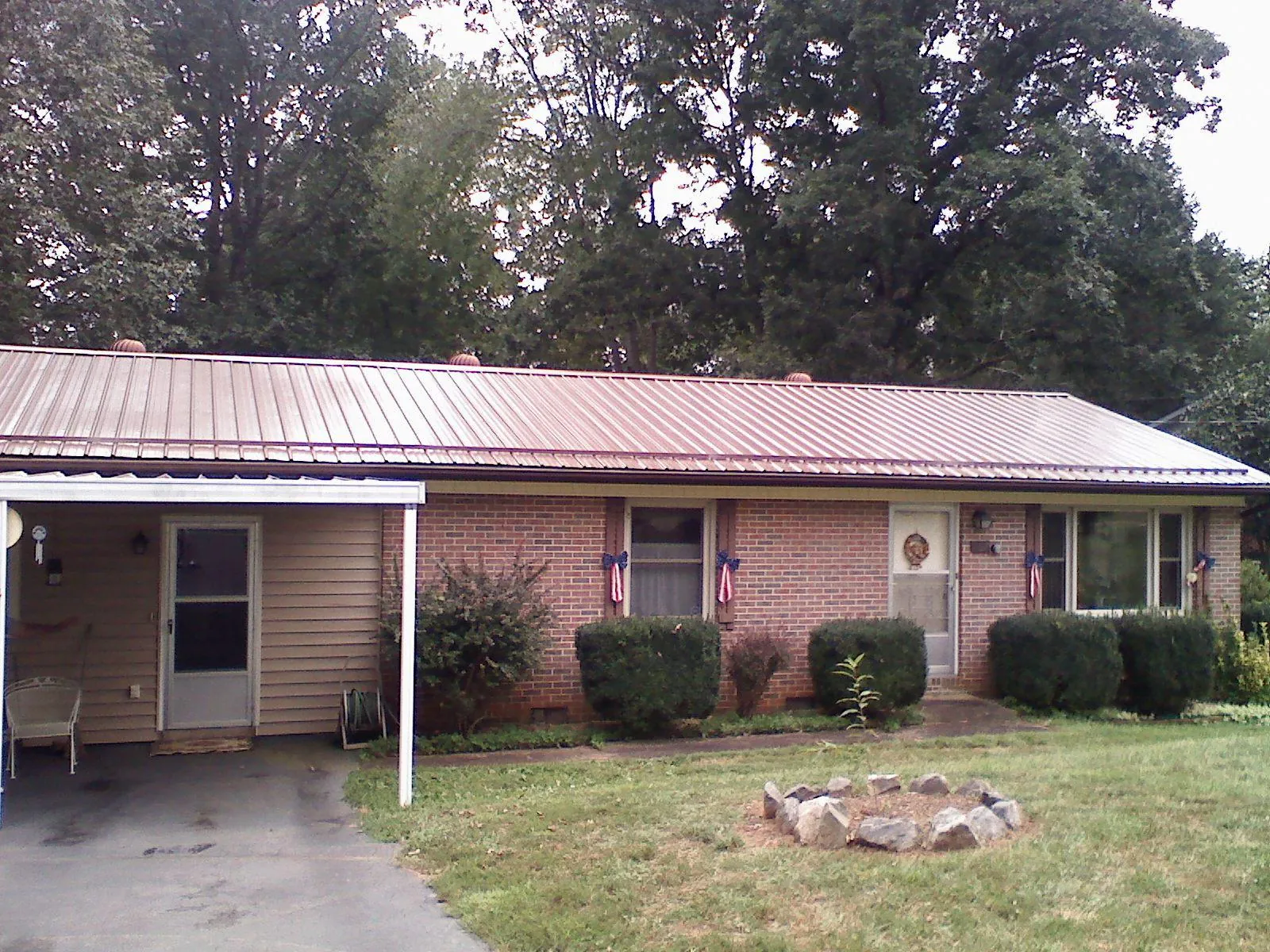 Bronze metal roof and carport on a brick ranch home — Roof Repair work by our crew in Hickory